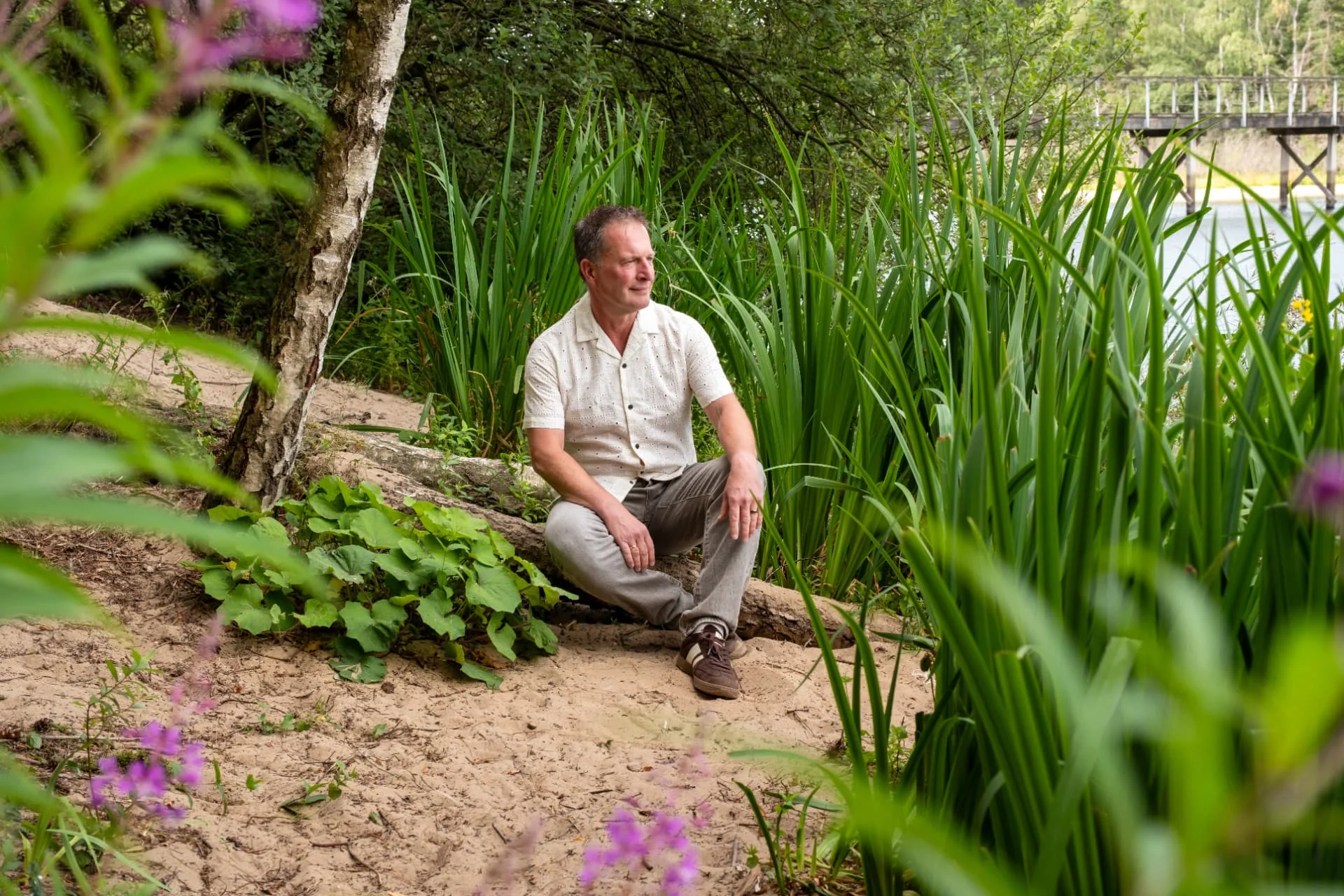 Bas van der Zwaan van ZwaanZinnig! zit buiten bij een meer tussen groen
