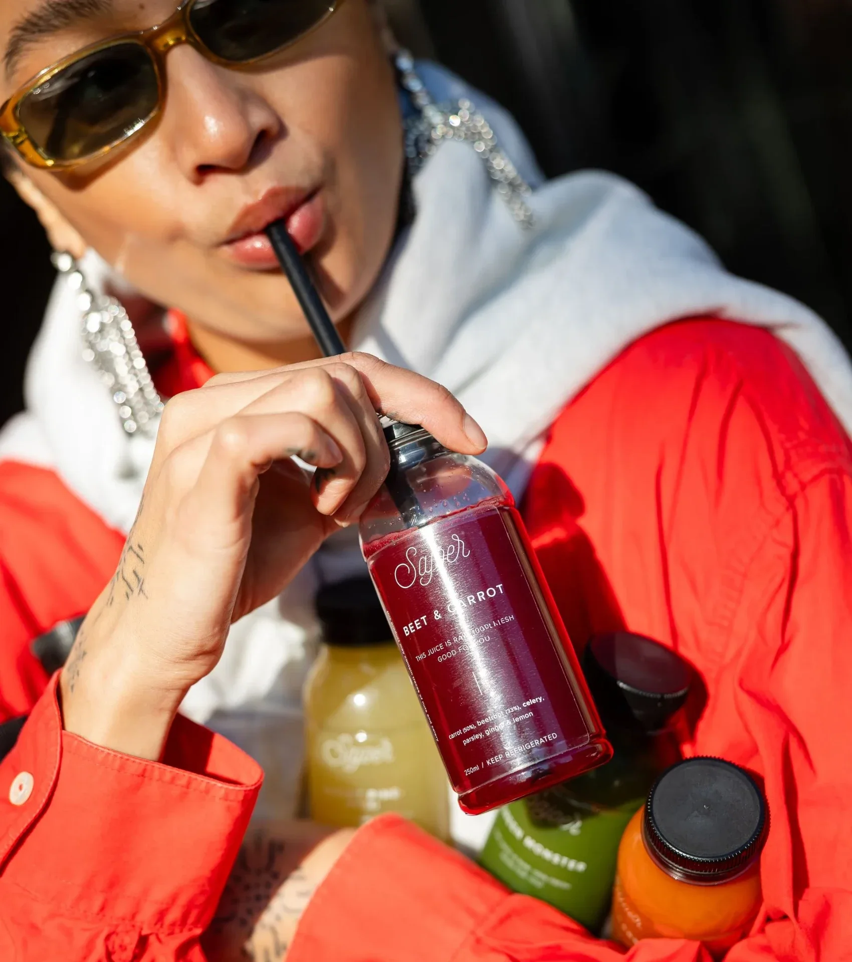 Klant drinkt met een rietje uit een fles Sajoer beet & carrot